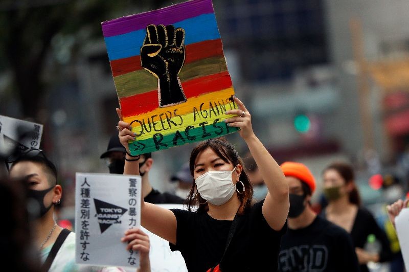 A demonstrator wearing a mask holds a placard during a protest march over the alleged police abuse of a Turkish man, in echoes of a Black Lives Matter protest, following the death of George Floyd who died in police custody in Minneapolis, in Tokyo, Japan June 6, 2020.   REUTERS/Issei Kato